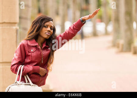 Pretty African woman hailing taxi Banque D'Images