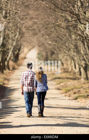 Vue arrière de charmante jeune couple en train de marcher sur les routes de campagne à l'automne Banque D'Images