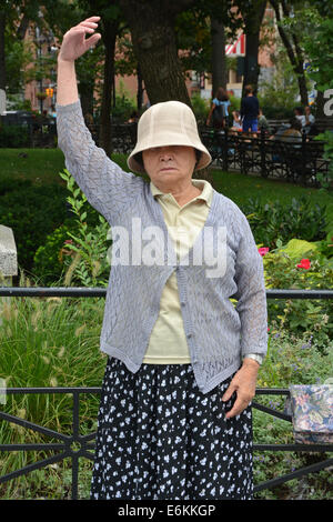 Une vieille femme chinoise Falun Dafa en exercices pratiques Union Square Park à New York. C'est position debout du Falun thh. Banque D'Images