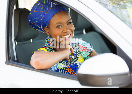 Jolie jeune femme africaine en vêtements traditionnels à l'intérieur d'une voiture Banque D'Images