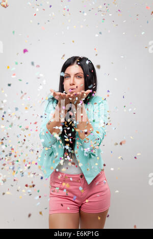 Belle jeune femme en ambiance de fête avec les confettis tout autour de Banque D'Images