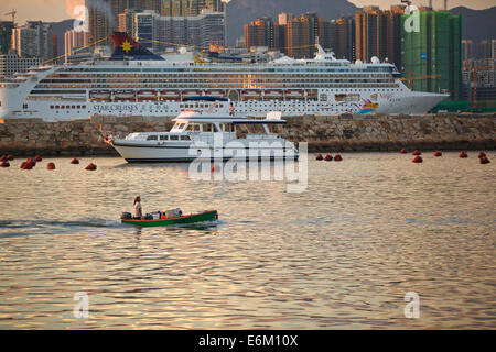 Navires contrastées. Petit bateau dans le Causeway Bay Typhoon le logement et un bateau de croisière en passant par le port de Victoria, l'horizon de Hong Kong derrière. Banque D'Images