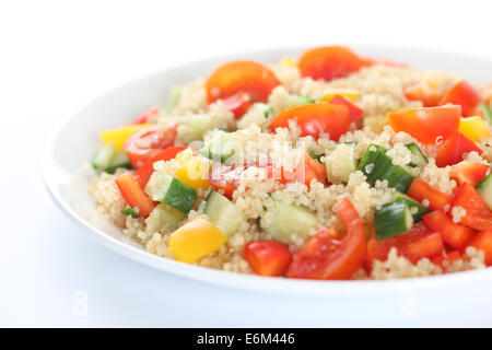 Salade de quinoa vegan. Ingrédients : Quinoa, tomates cerises rouges, jaunes et poivron rouge, concombre. Banque D'Images