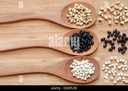 Les haricots dans une cuillères en bois : haricots blancs, haricots noirs et Black Eyed Peas. Banque D'Images