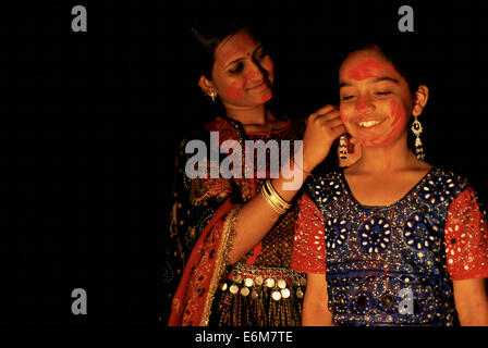 Femme hindoue et fille avec poudre rouge sur leur visage. Ils célèbrent le festival de Holi (Inde) Banque D'Images