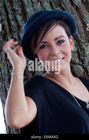 Jolie jeune femme sourit alors qu'elle détient sur son chapeau au festival victorieux 2014 UK Angleterre southsea Banque D'Images