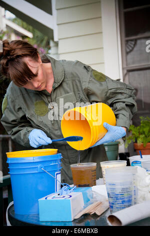 Woman pouring liquid dans un récipient Banque D'Images