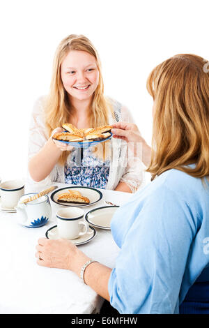 Teen fille servant de témoins pour sa mère lors d'une tea party. Isolé sur blanc. Banque D'Images