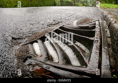 En bordure de l'aire de vidange débordant bloqué la route menant à plus de surface de l'eau sur la chaussée vide Banque D'Images