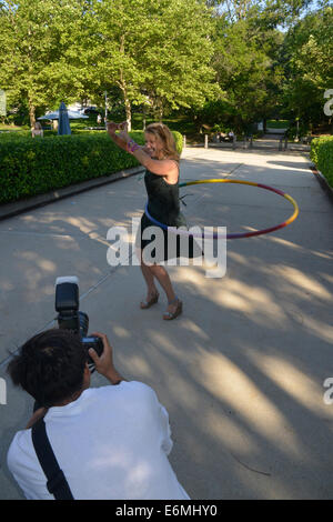 Femme bénéficie d'un hula hoop tandis qu'un photographe prend des photos de sa Banque D'Images