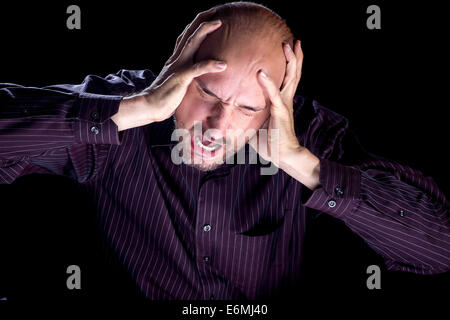 Une image spectaculaire d'un homme crier. Il est très stressé et l'éclairage spectaculaire contribue à le souligner. Banque D'Images