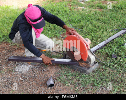 Worker cutting metal et l'étincelle avec machine de coupe Banque D'Images