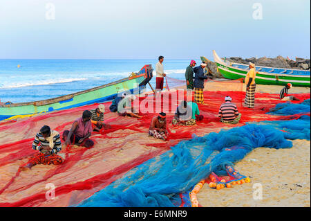 Les pêcheurs de la réparation des filets sur la plage, de la mer d'Oman, Cochin, Kerala, Inde du Sud, Inde Banque D'Images