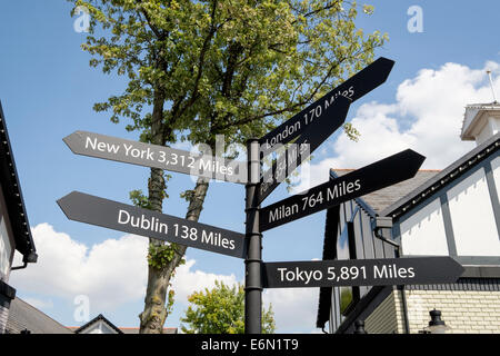 Les villes du monde en distances signpost Cheshire Oaks Shopping outlet. Ellesmere Port, Cheshire, Angleterre, Royaume-Uni, Angleterre Banque D'Images