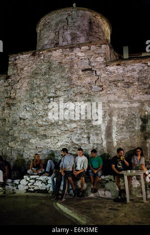 Les gens s'assoient en face de l'Église du Christ dans le vieux village (Chora) Alonnisos, Grèce sur août 2014. Banque D'Images