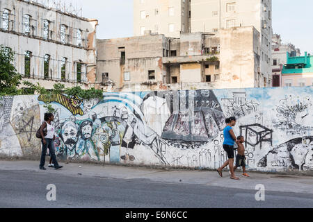 La mère et l'enfant marchant à côté mur avec graffiti, Paseo de Marti, La Havane, Cuba Banque D'Images