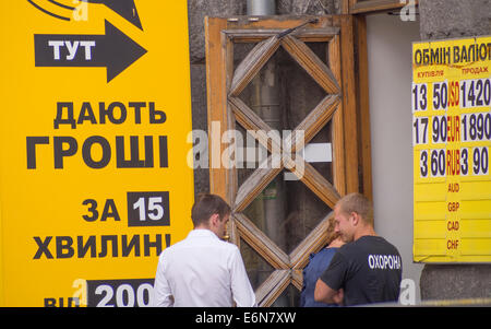 Bureaux de Change affichent leurs nouveaux taux de change hryvnia pour l'affaiblit un record à 14,20 dollar. -- Le Premier ministre ukrainien Arseny Iatseniouk crie le danger de la chute de la hryvnia si le conflit dans l'Est demeure. L'Ukraine est en attente d'une tranche de l'aide du FMI qui est réputée pour aider à stabiliser la monnaie. Crédit : Igor Golovnov/Alamy Live News Banque D'Images