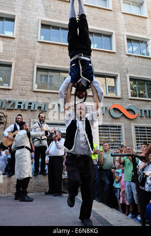 Jérusalem, Israël. 27 août, 2014. Musiciens, danseurs et acrobates, qui trouvent un sens et d'expression de leur âme par la musique Klezmer juive traditionnelle et portant des costumes traditionnels et des atours klezmer Hassidique, a ouvert le Festival Klezmer International de Jérusalem dans le quartier des rues du centre-ville. Credit : Alon Nir/Alamy Live News Banque D'Images