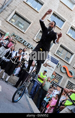 Jérusalem, Israël. 27 août, 2014. Musiciens, danseurs et acrobates, qui trouvent un sens et d'expression de leur âme par la musique Klezmer juive traditionnelle et portant des costumes traditionnels et des atours klezmer Hassidique, a ouvert le Festival Klezmer International de Jérusalem dans le quartier des rues du centre-ville. Credit : Alon Nir/Alamy Live News Banque D'Images