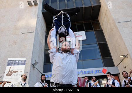 Jérusalem, Israël. 27 août, 2014. Musiciens, danseurs et acrobates, qui trouvent un sens et d'expression de leur âme par la musique Klezmer juive traditionnelle et portant des costumes traditionnels et des atours klezmer Hassidique, a ouvert le Festival Klezmer International de Jérusalem dans le quartier des rues du centre-ville. Credit : Alon Nir/Alamy Live News Banque D'Images