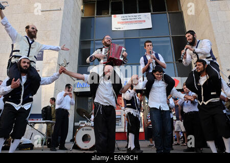 Jérusalem, Israël. 27 août, 2014. Musiciens, danseurs et acrobates, qui trouvent un sens et d'expression de leur âme par la musique Klezmer juive traditionnelle et portant des costumes traditionnels et des atours klezmer Hassidique, a ouvert le Festival Klezmer International de Jérusalem dans le quartier des rues du centre-ville. Credit : Alon Nir/Alamy Live News Banque D'Images