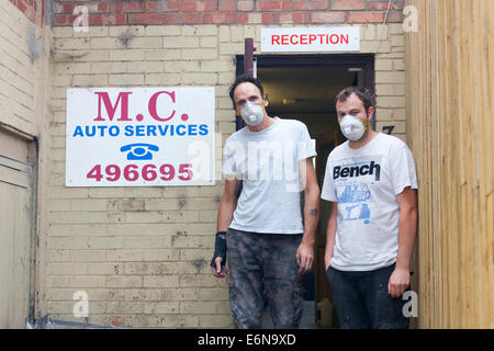 Marshgate, Swindon, Wiltshire, Royaume-Uni. 27 août 2014. Malcolm Curwen et fils de M.C. Services Automobile porter un masque de visage pour tenter de minimiser les effets toxiques de l'âcre fumée provenant de la combustion des déchets à Averies pile Recyclage, juste à côté de leur entreprise. Les déchets couve depuis le 21 juillet 2014 et l'incendie est maintenant abordé par les pompiers de Swindon, Marlborough, Royal Wooton Bassett et ailleurs dans le Wiltshire. Crédit photo : John Henshall 2014 / Alamy Live News. JMH6382 Banque D'Images