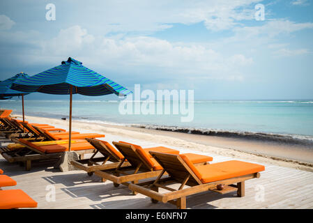 De nombreuses chaises longues avec parasols à la plage sur l'océan Banque D'Images