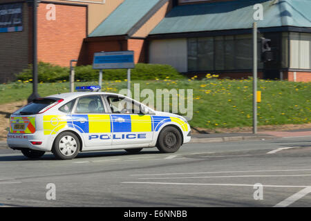 Déménagement voiture de police identifiée, Ford Focus, avec feux bleus clignotants dans un milieu urbain à Bolton, Lancashire. Banque D'Images