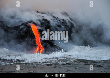 L'augmentation de vapeur au large de l'océan qui s'écoule dans la lave, Kilauea Volcano, Hawaii Islands, USA au crépuscule Banque D'Images