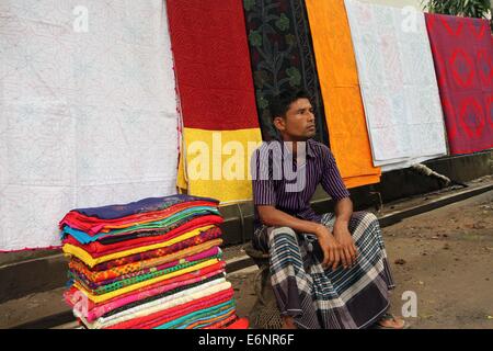 Dhaka 2014. Un vendeur de rue est la vente Nakshi kantha à Dhaka. Banque D'Images