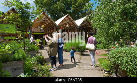 Les visiteurs admirent le jardin de la communauté Dalston Eastern Curve tout en discutant avec Jardins urbains de jardinier est de Londres E8 Angleterre Grande-Bretagne Royaume-Uni KATHY DEWITT Banque D'Images