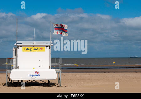 Station de sauvetage de la RNLI de vol d'un drapeau, sur une plage déserte British. Banque D'Images