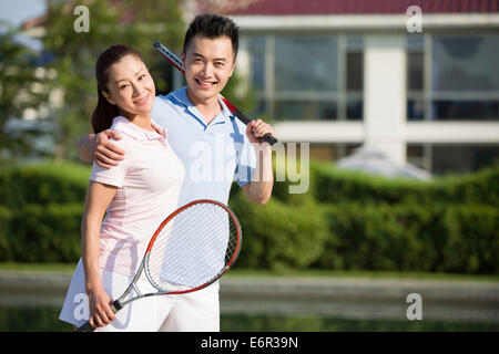 Portrait de jeune couple avec des raquettes de tennis Banque D'Images