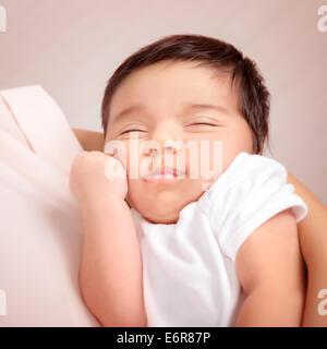 Closeup portrait de l'adorable enfant arabe dormir sur les mains, les mères peu innocent baby, la paix et l'harmonie concept Banque D'Images