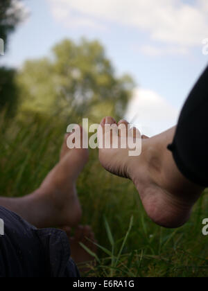 Les deux pieds, prises allongé dans l'herbe un jour d'été Banque D'Images