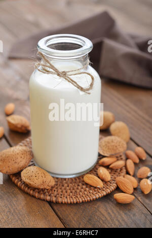 Bouteille de lait d'amande avec les écrous à fond de bois Banque D'Images