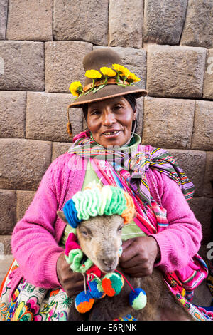 Femme Quechua en vêtements traditionnels avec un bébé lama - Cusco, Pérou Banque D'Images