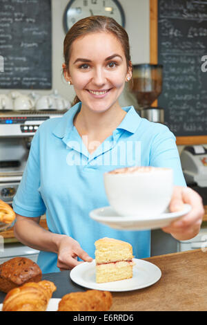 Serveuse dans Café servant du café avec la clientèle Banque D'Images