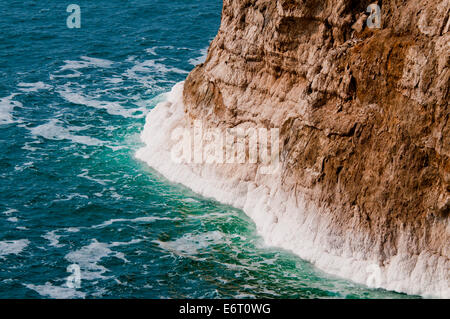 Les incrustations de sel au bas de falaises sur la côte jordanienne de la Mer Morte Banque D'Images