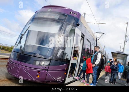 Les passagers à bord d'escalader l'un des plus récents ajouts à la flotte de tram Banque D'Images