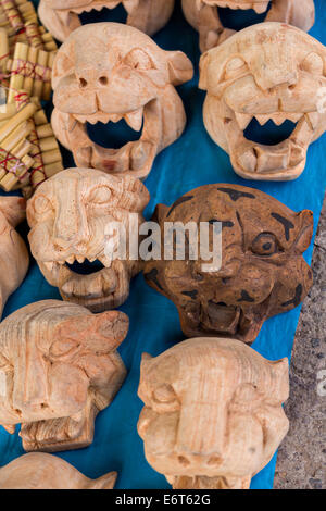 En bois sculpté main jaguar masques au marché du dimanche de Tlacolula de Matamoros, Mexique. Le marché de la rue régionale attire des milliers de vendeurs et consommateurs de l'ensemble de la Valles centrales de Oaxaca. Banque D'Images