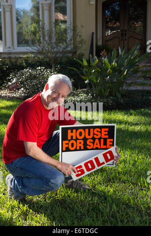 Propriétaire de maison mature plaçant sa maison de banlieue à la vente. USA Banque D'Images