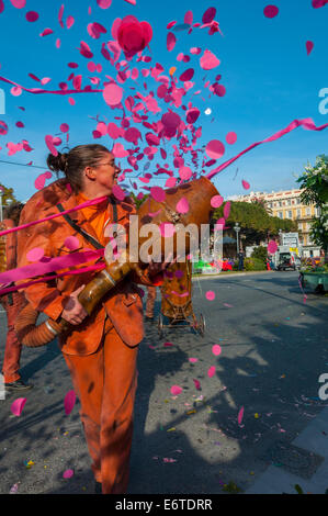 Nice, France, femme en costume, jetant des confettis en face de foule sur rue au défilé de carnaval de printemps traditionnel Banque D'Images