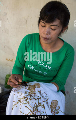 Yogyakarta, Java, Indonésie. La production de Batik. Femme à l'aide de la cire chaude pour esquisser un dessin sur un tissu Batik. Banque D'Images