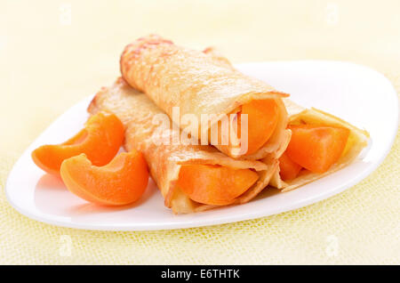 Crêpes avec tranches d'abricots on white plate Banque D'Images