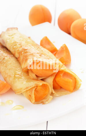 Crêpes avec tranches d'abricots on white plate Banque D'Images