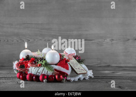 Deuxième Avènement : deux brûler des bougies décorées en blanc et rouge sur fond gris en bois. Banque D'Images