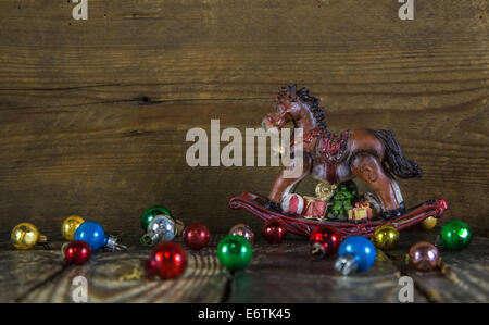 Noël arrière-plan coloré avec un vieux cheval à bascule et boules. Banque D'Images