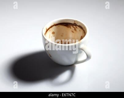 Sale et vide la tasse de café blanc avec des taches de café. Banque D'Images