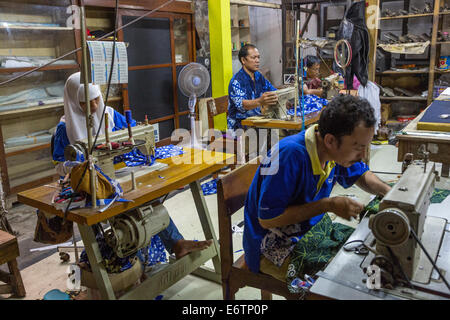 Yogyakarta, Java, Indonésie. Atelier batik. Les hommes et les femmes en tissu à coudre. Banque D'Images